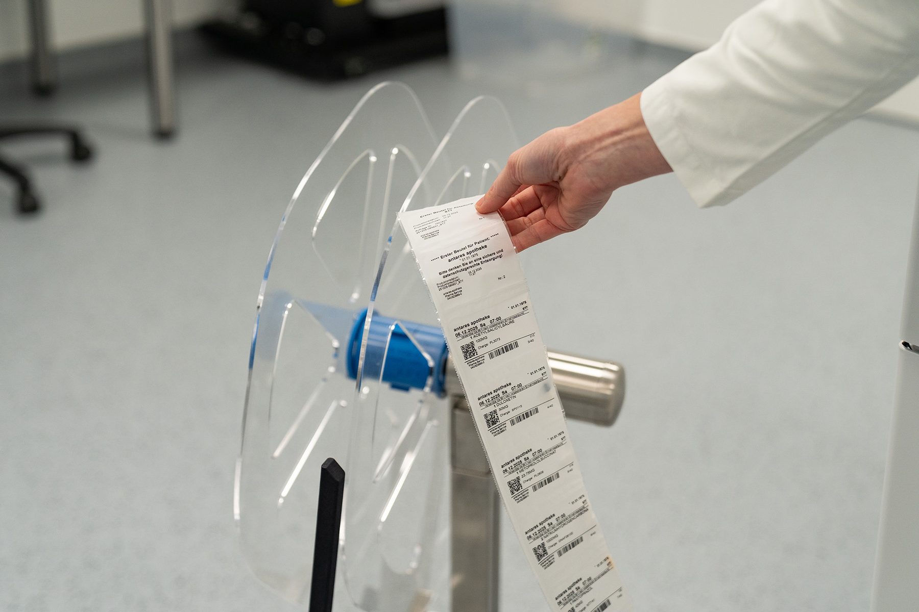 Schlauchblister mit patientenindividuell gefüllten Beuteln auf der Abrollvorrichtung im Verblisterungsraum der antares Apotheke